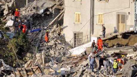 Search and rescue teams survey the rubble of collapsed buildings in Pescara del Tronto.