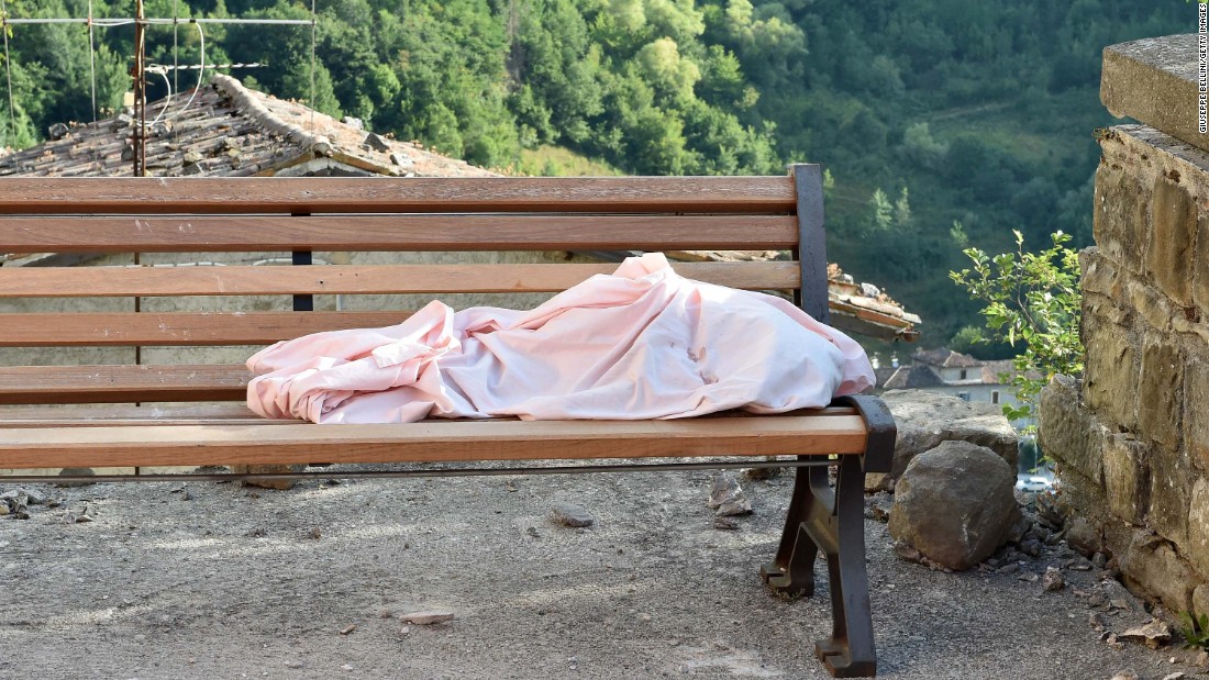 The body of a unidentified child lies on a bench in Arquata del Tronto on August 24.