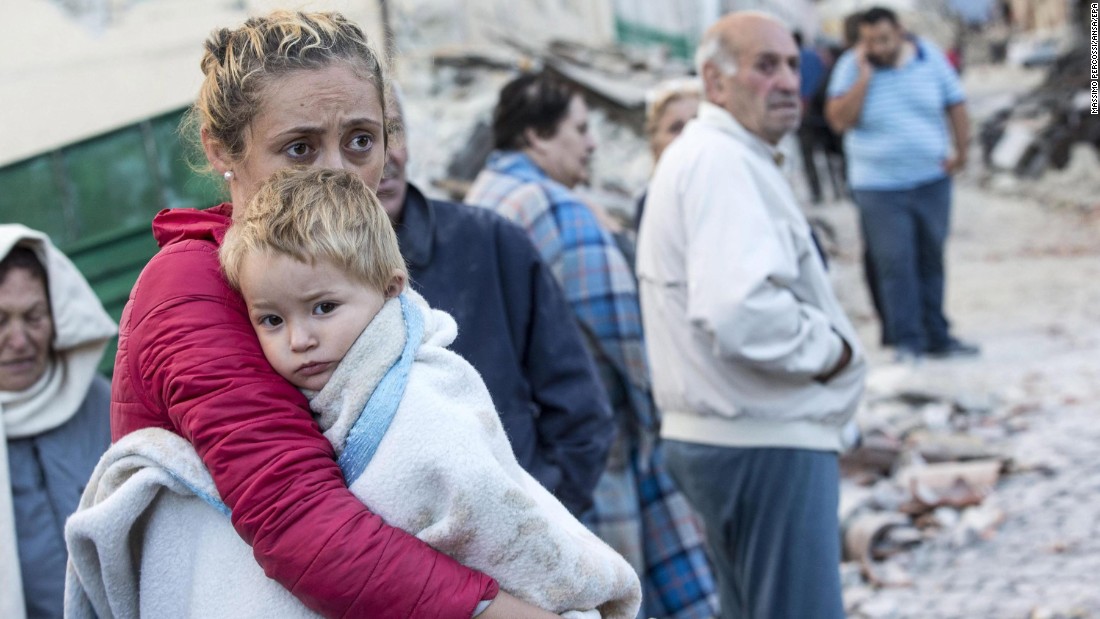 A woman tries to comfort her child in Amatrice on August 24.