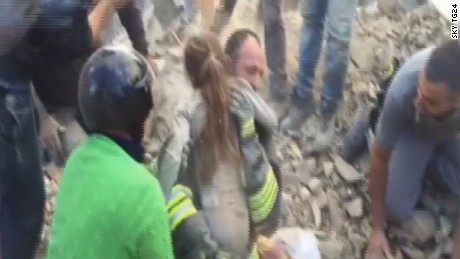 A girl is pulled from earthquake rubble. 