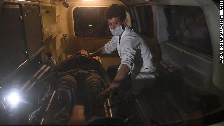 A responder assists an injured man in an ambulance in the aftermath of the university attack. 