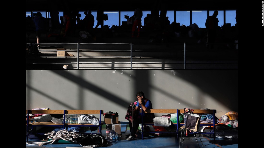 A man rests on a bench after spending the night in a makeshift camp set up inside a gym in Amatrice on August 25.