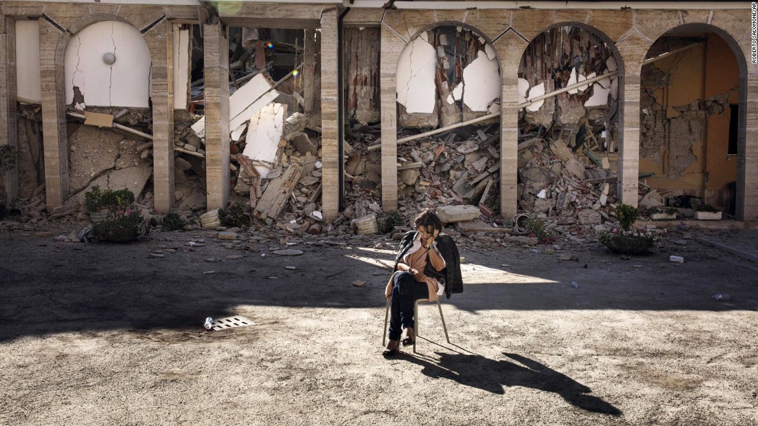 A woman rests in the courtyard of a convent in Amatrice on August 26.