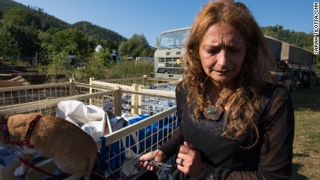 AnnaMaria tends to her cat near a staging area for the camp&#39;s emergency supplies. In the immediate aftermath of the quake, she and her family were trapped in their holiday home.