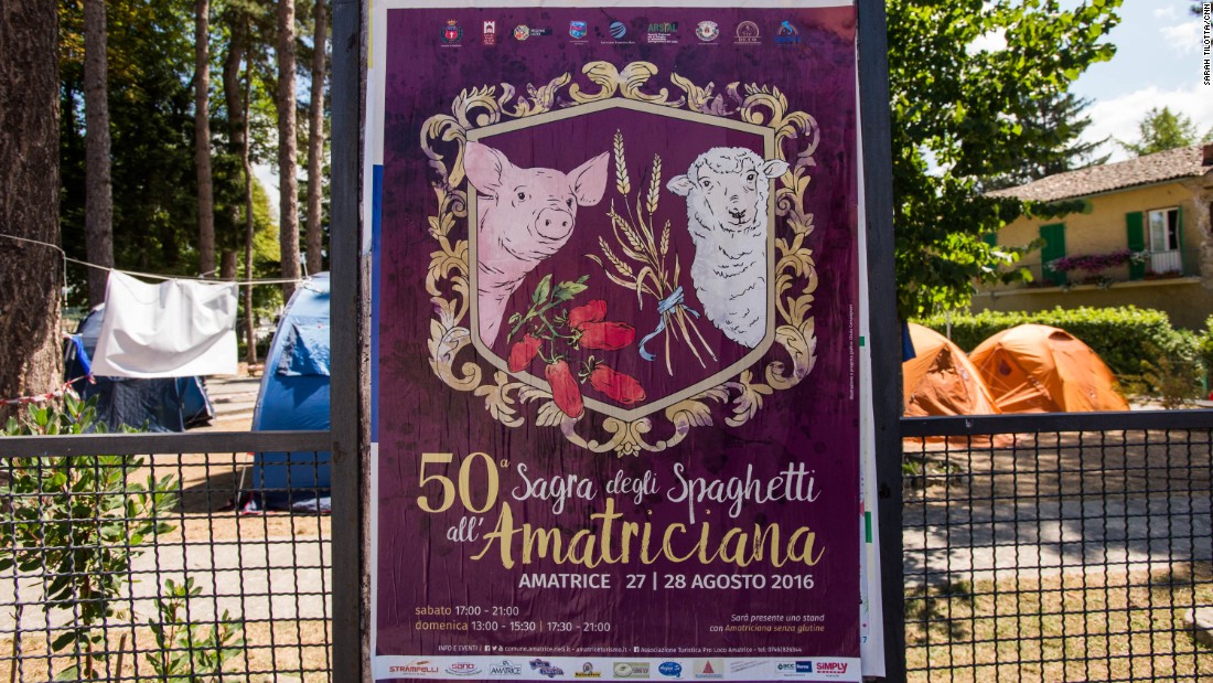 A poster for the 50th anniversary of Amatrice&#39;s famous pasta festival, set to take place the weekend following the earthquake, remains on the perimeter of a park now occupied by emergency response volunteers.