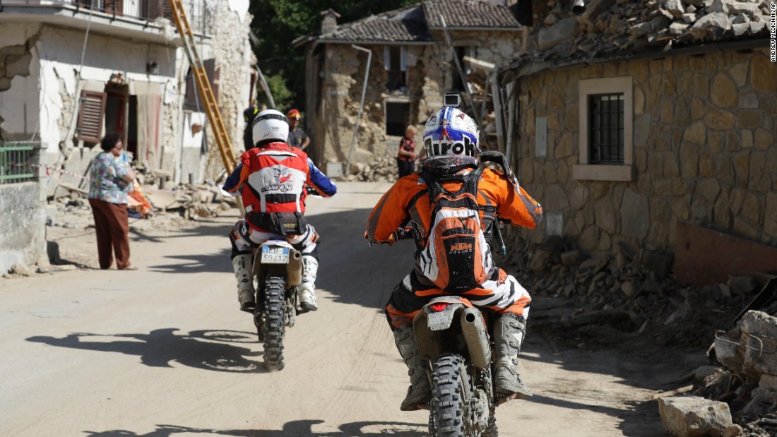 Volunteers on motorbikes drive through the town of Villa San Lorenzo a Flaviano, Italy, on August 28 as they bring supplies to smaller villages. 