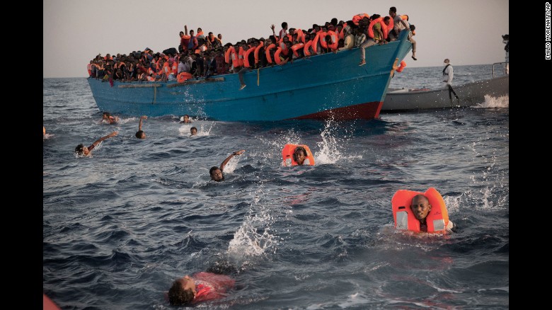 Migrants, most of them from Eritrea, jump into the Mediterranean from a crowded wooden boat during a rescue operation about 13 miles north of Sabratha, Libya, in August 2016.