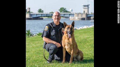 Officer Fred Laitinen kneels beside his canine partner &quot;Cops&quot;. Courtesy Eric Jaeger