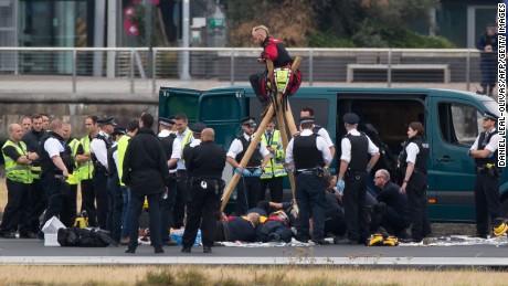 Emergency services surround Black Lives Matter protesters Tuesday on a London City Airport runway.
