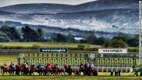 Runners break from the stalls in the back straight  at Curragh race course.