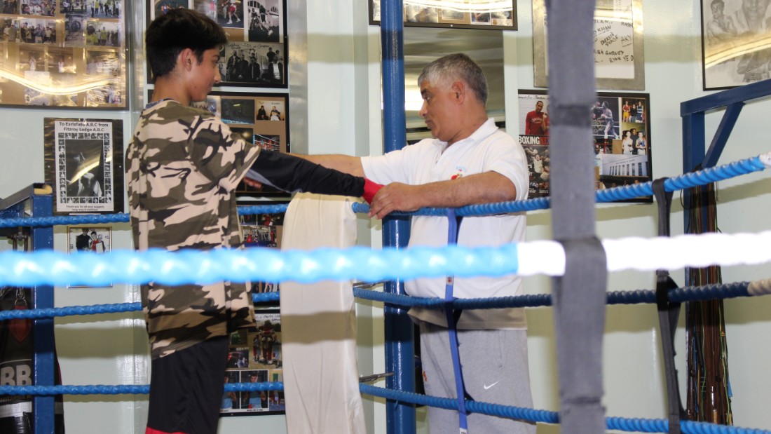 The club opens its doors to amateur boxers of all different levels and both sexes, four days a week. Here, Sid Khan tapes the gloves of a young fighter while offering words of advice. 