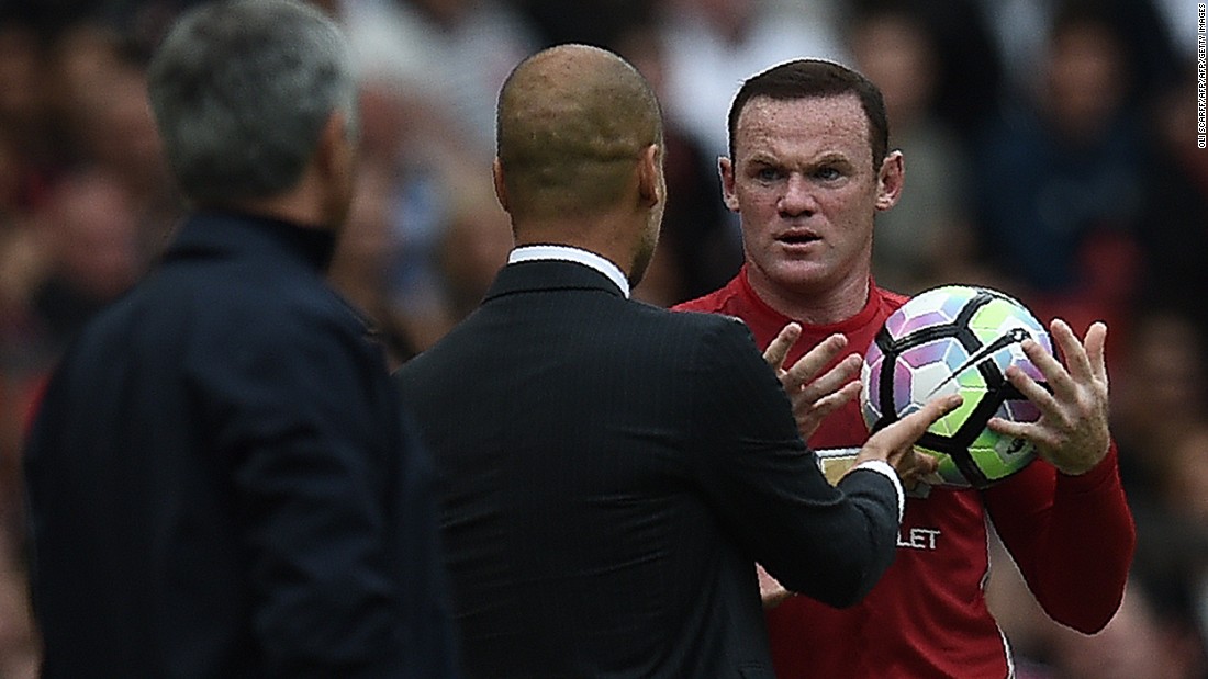 Manchester United&#39;s English striker Wayne Rooney (R) and Manchester City&#39;s Spanish manager Pep Guardiola clash on the touchline as Rooney tries to retrieve the ball.