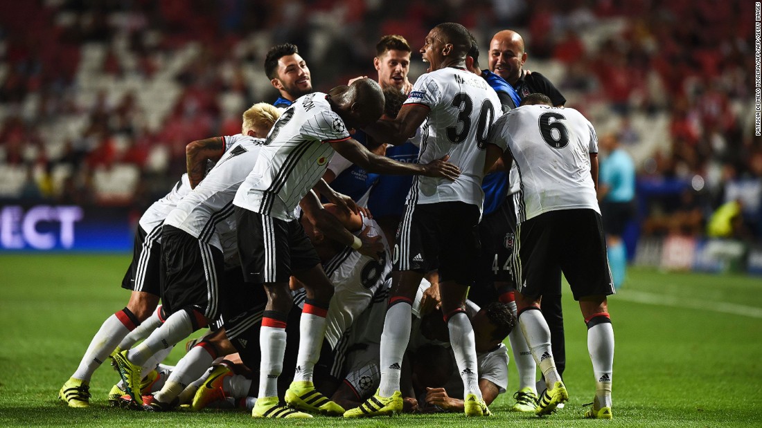 Talisca is buried by his Besiktas teammates after scoring a dramatic long-range free-kick -- converted in the 93rd minute -- to earn a 1-1 draw against parent club Benfica. 