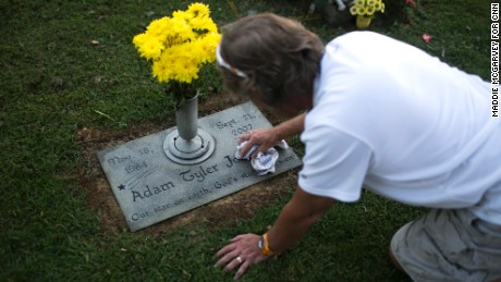 Teddy Johnson polishes the grave of his son, Adam, who died of a heroin overdose in 2007. 