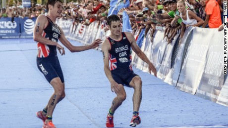 Alistair Brownlee (L) helps his brother Jonny (R) cross the line during the 2016 ITU World Triathlon Championships.