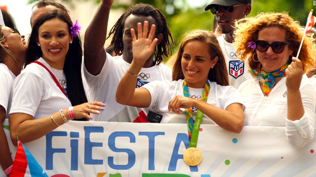 Tennis player Monica Puig waves to the crowd after arriving back in Puerto Rico from the Rio 2016 Olympics, where she became her country&#39;s first gold medalist.