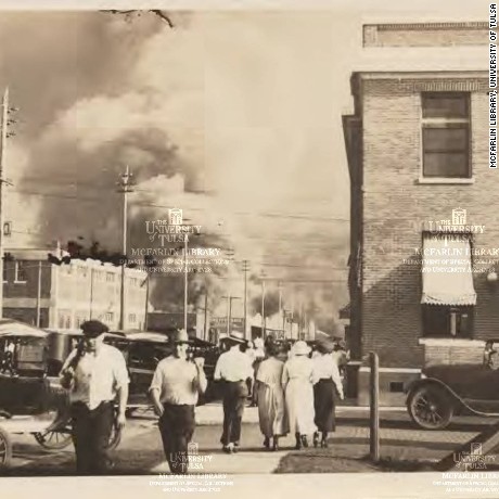 Onlookers watch as a fire erupts during the Tulsa race riot in 1921. 