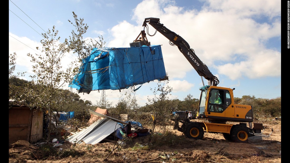 A digger lifts a migrant&#39;s makeshift tent during a destruction operation in September 2009.
