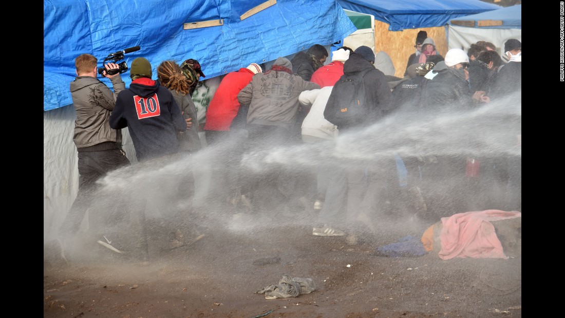 Riot police spray water on migrants to disperse them during the dismantling of half of &quot;The Jungle&quot; on February 29.