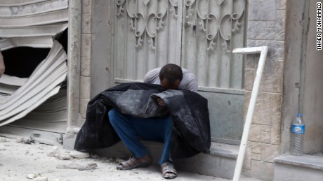 Mahmoud Sawas' uncle holds the boy's body after Friday's airstrike.