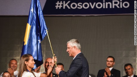 Kosovo&#39;s President Hashim Thaci  hands over the national flag to the Kosovar judoka Majlinda Kelmendi. 