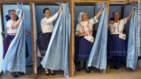 Hungarian women wearing traditional clothes cast their ballot at a polling station Sunday in Budapest.