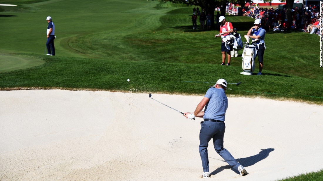 Lee Westwood of Europe hits out of a bunker on the first hole during singles matches. His opponent Ryan Moore later sealed the victory for the US.
