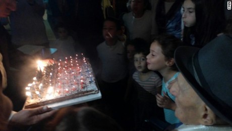 Kristal watches on as younger family members help blow out his candles.