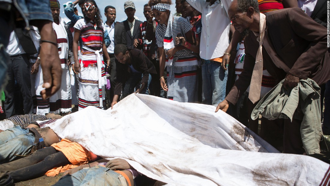 A man covers the bodies of festival goers who were killed in the stampede. 