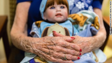 Vivian Guzofsky, 88, holds a baby at Sunrise Senior Living in Beverly Hills, California, on August 2, 2016. Some nursing homes are using a technique called doll therapy to ease anxiety among their residents with dementia.  (Heidi de Marco/KHN)