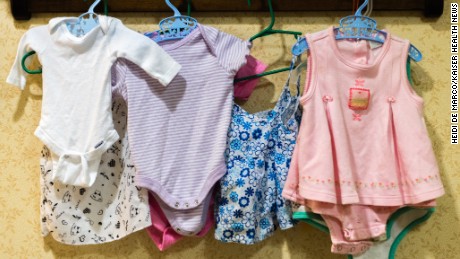 Baby clothes hang on the wall of the nursery area at Sunrise Senior Living.