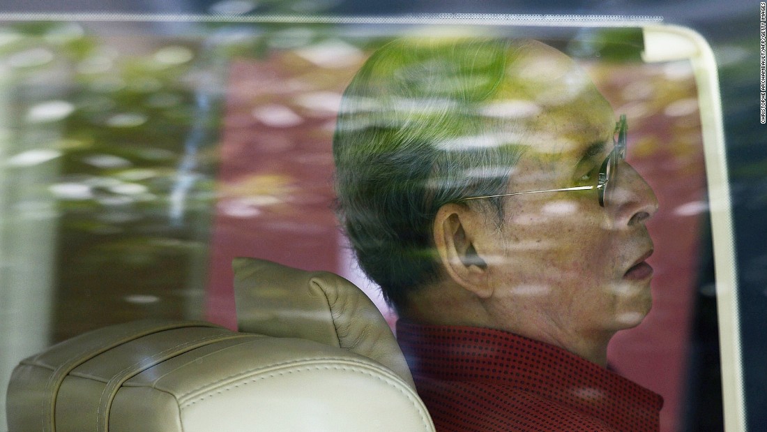 The King is seen through a car window as he leaves the Siriraj hospital in Bangkok in 2015.