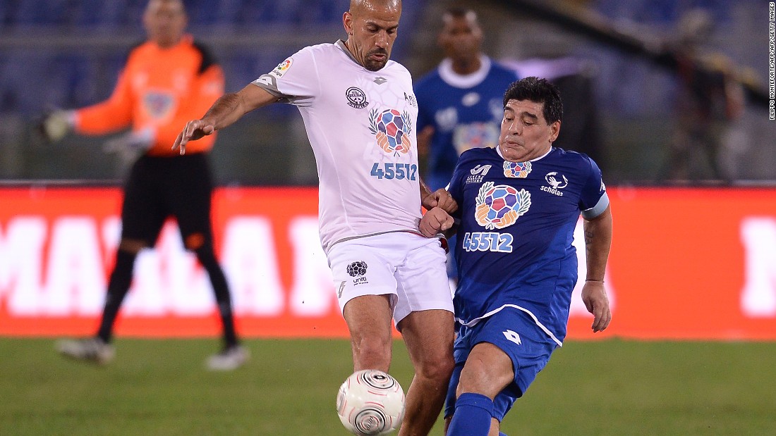 Diego Maradona clashes with Juan Sebastian Veron (left) during the &quot;United for Peace&quot; match in Rome, leading to the former being helped from the pitch enraged at half-time. Pope Francis helped organize the game, which featured footballing greats from around the world.