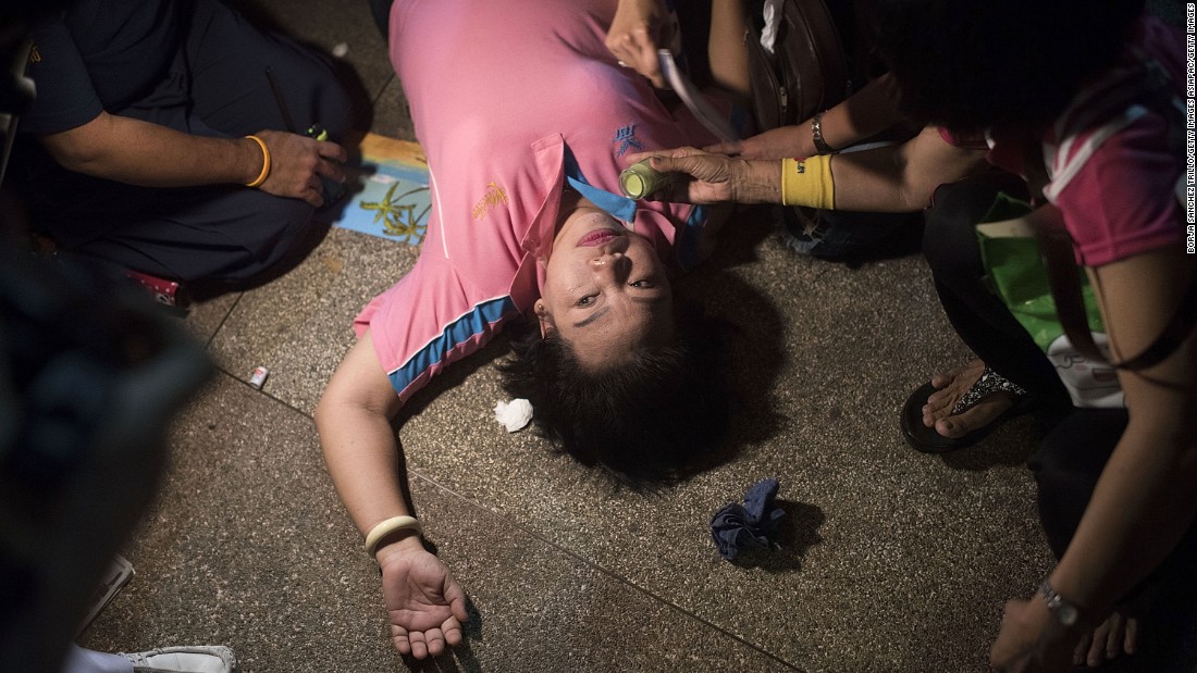 A woman passes out after an official statement announces the death of the king.