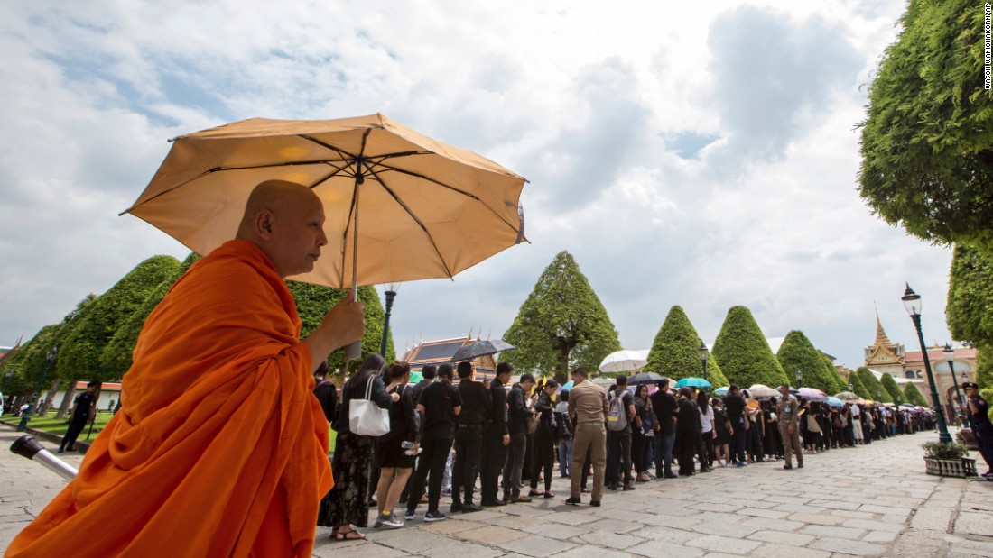 A Buddhist monk stands next to line of mourners waiting to pay their respects to the body of the late King Bhumibol Adulyadej at the Grand Palace in Bangkok, October 15, 2016.