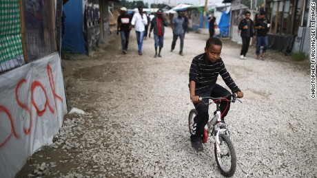 A boy rides his bicycle in the &quot;Jungle&quot; migrant camp in Calais, France.