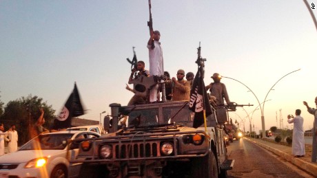 ISIS fighters parade down a main road in Mosul in 2014.