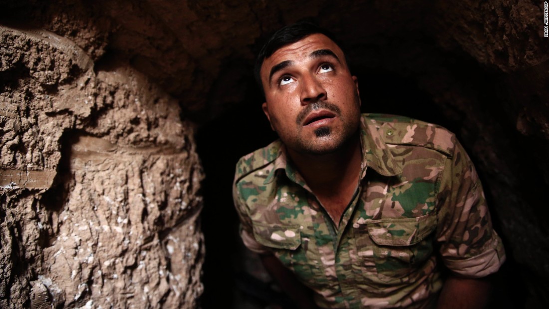 A Peshmerga fighter peers up from an underground tunnel in the liberated town of Badana on October 18. ISIS fighters have built tunnels below residential streets to escape from airstrikes.