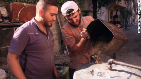 An eastern Aleppo man makes fuel from heated plastic. Residents say one kilogram of plastic can make a liter of fuel.