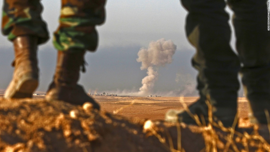 Peshmerga fighters look over a village during an assault near Bashiqa on Thursday, October 20.