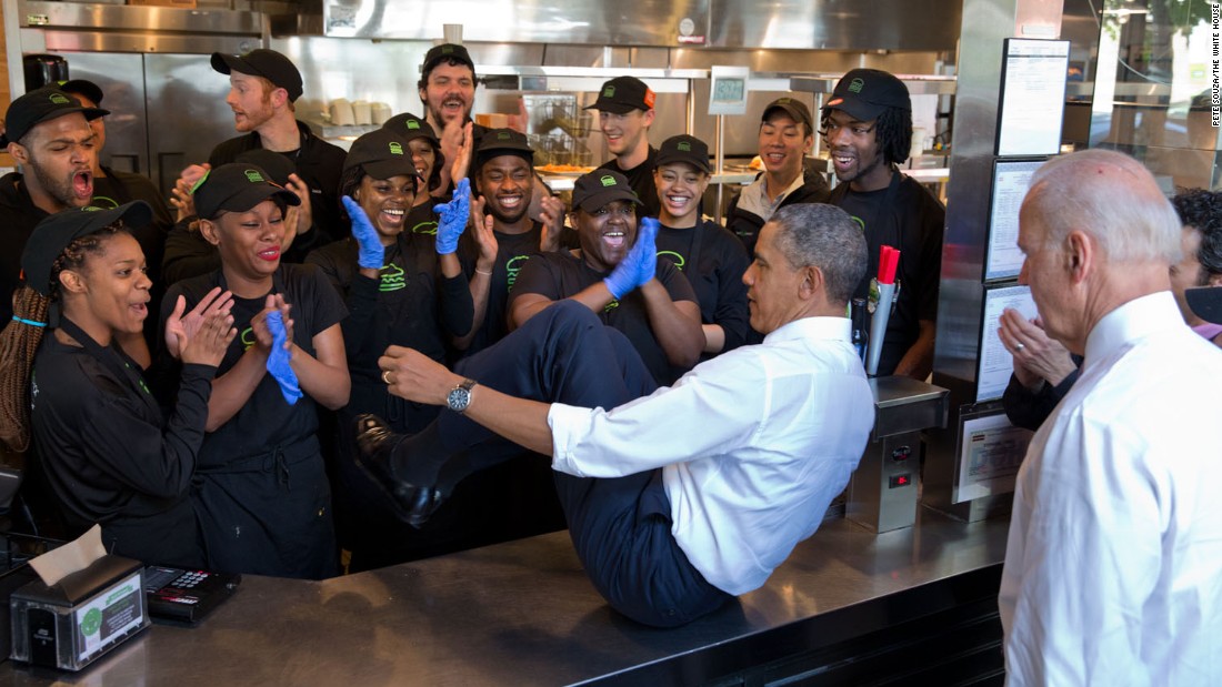 Obama slides across a counter to pose with staff members at a Shake Shack restaurant in Washington on May 16, 2014. Vice President Joe Biden, lower right, also did the same. &quot;The President normally does a group photo with restaurant staff when he stops for lunch or dinner,&quot; White House Photographer Pete Souza said.