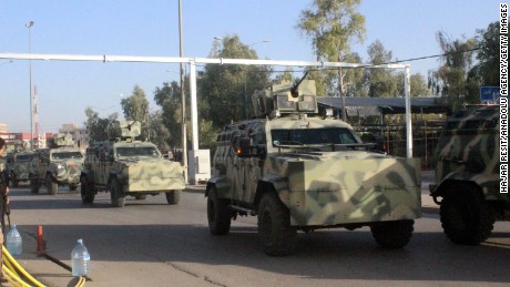 Security forces arrive with armored vehicles Friday after ISIS attacks in Kirkuk, Iraq.