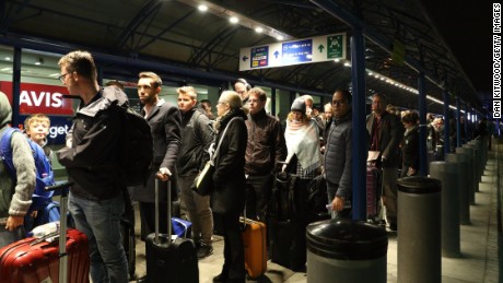 Passengers queue outside terminal.