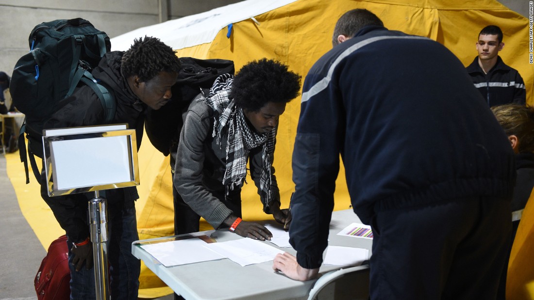 Migrants register with French authorities on October 24 before boarding buses that will transport them to shelters across France.