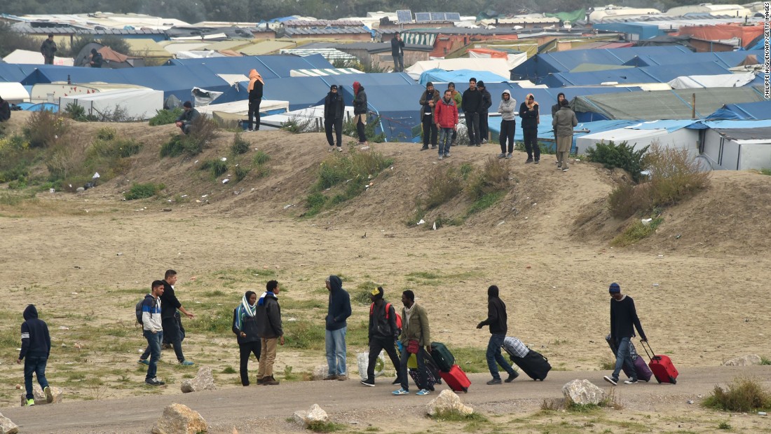 Migrants leave their makeshift homes on October 24.