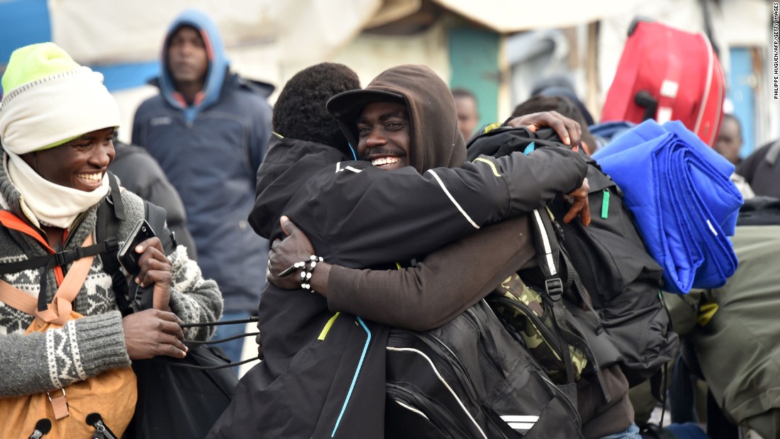 Residents of the camp hug before departing the &quot;Jungle&quot; on October 24.