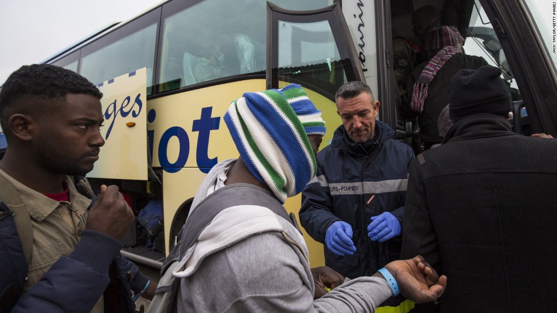 Migrants board buses that will transport them to shelters around France on October 24. Those applying for asylum will be offered temporary accommodation in a shelter while their claim is processed.