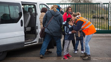 Care workers bring child migrants to a reception point outside the Jungle migrant camp before boarding buses to refugee centers around France.