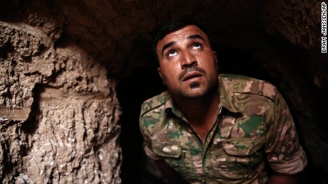 A Peshmerga fighter peers up from an underground tunnel in the liberated town of Badana on October 18. ISIS built tunnels below residential streets to escape from airstrikes.