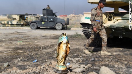 An Iraqi soldier walks past a broken statue of the Virgin Mary in the predominantly Christian village of Bartella on October 23.